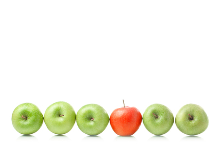 Red apple standing out from large group of green apples. Horizontal shapeの写真素材