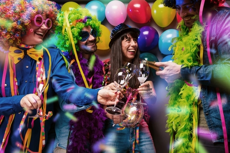 Happy girls and boys at Carnival Party clinking glasses with champagneの写真素材