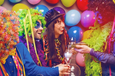 Happy girls and boys at Carnival Party clinking glasses with champagneの写真素材