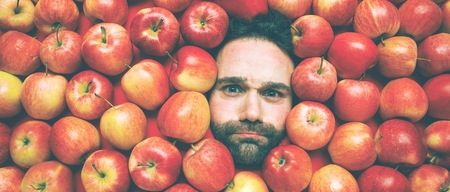Food industry. Face of laughing man in apple plane. Creative background with apples for your productの写真素材