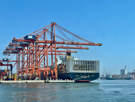 Container Cargo freight ship with working crane bridge in shipyard for Logistic Import Export backgroundの写真素材