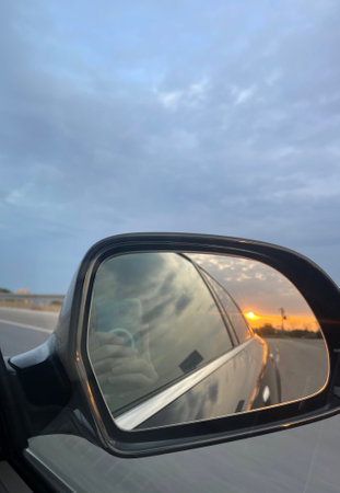 Mirror of car on the road with beautiful sky at sunset.の写真素材