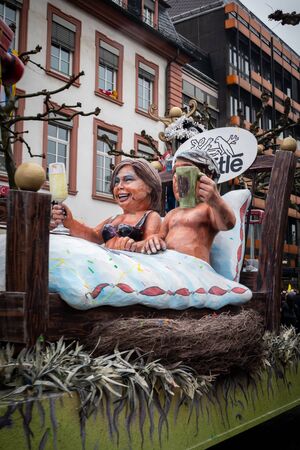Float with man and woman in bed drinking together at the Rose Monday parade in Mainz, Germany.のeditorial素材