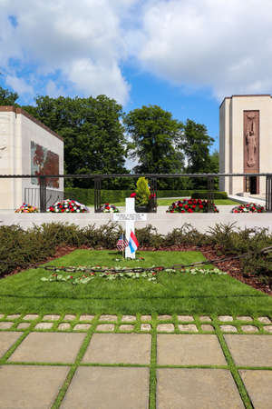 General Patton's grave at the Luxembourg American Cemetery and Memorial with flowers and the American and Luxembourg flags.のeditorial素材