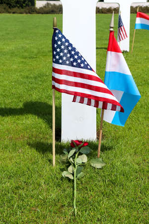 American and Luxembourg flags and a rose on a grave at the Luxembourg American Cemetery and Memorial  Memorial Day weekend.のeditorial素材