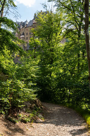 Hiking path in the forest with Burg Eltz in the background on a spring day in Germany.