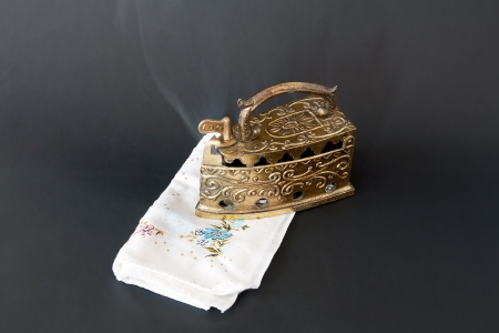 Old iron in action  White fabric and black backgroundの写真素材