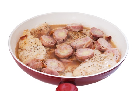 Chicken breast and pork roll in white wine, in a hot pan  Isolation on white の写真素材