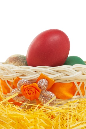 Colorful easter eggs in a basket isolated on white backgroundの写真素材