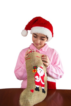 Smiling Girl with Santa Claus Hat holding christmas sock and gift box. Focus in gift box. Isolated on whiteの写真素材