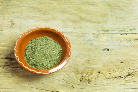 Dry parsley in the bowl, on wooden tableの写真素材