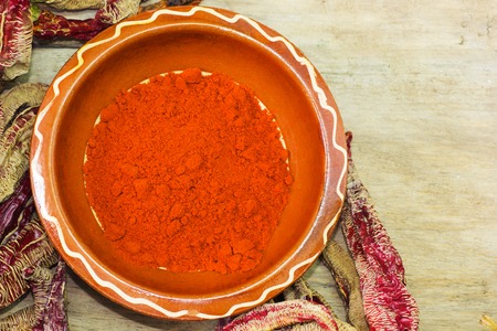 Cayenne Pepper in the bowl, on wooden tableの写真素材