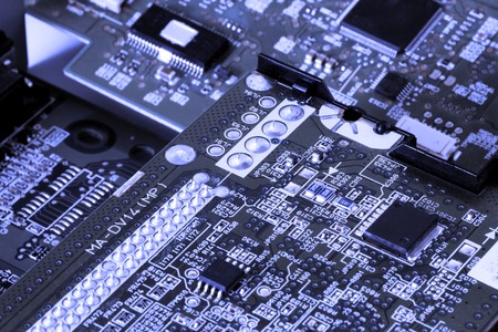 Close up of electronic circuit board with processor. Blue background.