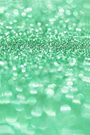 Green Glitter for Christmas Background with Blurred Lights.
