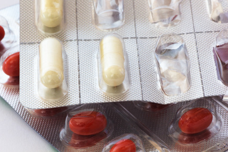 Red and White Capsules in blister, close up. Medical Background.
