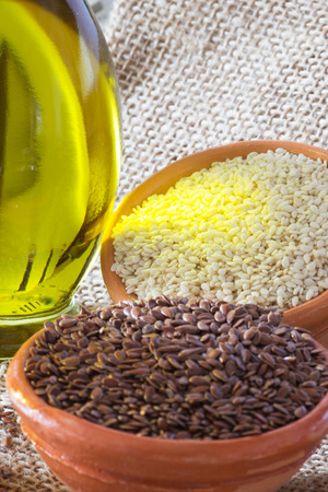 Bowls with Brown Flax Seed and White Sesame Seeds and Bottle of Oil.の写真素材