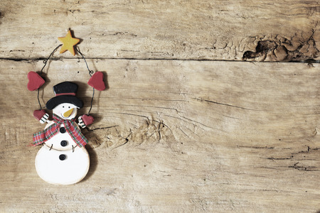 Snowman on Rustic Wooden Background. Christmas Background. Image is Retro Filtered.の写真素材