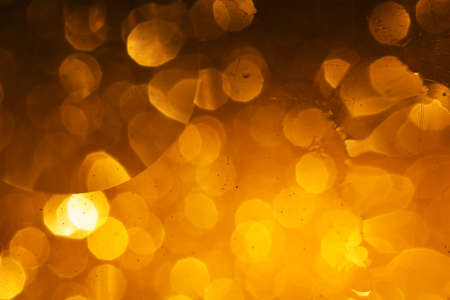 Abstract and festive background with golden yellow lights. De focused blurred lights.の写真素材
