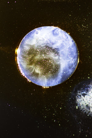 Abstract background with liquid and drops over a blurred backdrop, close up.