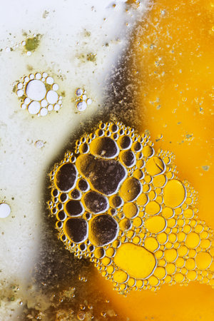 Abstract background with liquid and drops over a blurred backdrop, close up.