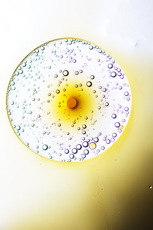 Abstract background with liquid and drops over a blurred backdrop, close up.