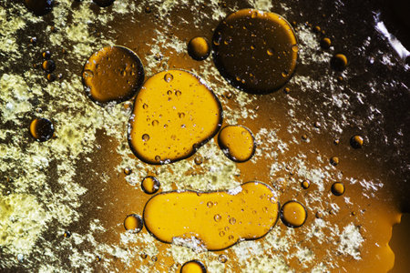 Abstract background with liquid and drops over a blurred backdrop, close up.