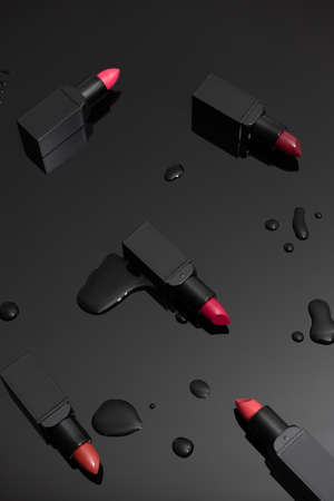 Lipticks and drops of water on black backgroundの写真素材