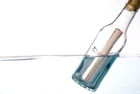 Message in a bottle floating in waterの写真素材