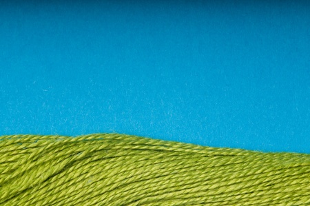 Green thread that looks like grass and blue background as a skyの写真素材