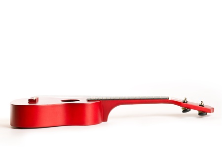 A red guitar laying down on white backgroundの写真素材