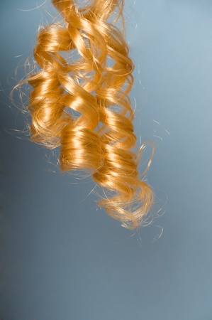 Blonde curly hair with blue backgroundの写真素材