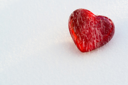A cold frozen red heart in the snow.の写真素材