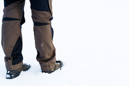 A pair of legs and boots in the snow, Plenty of white copy space