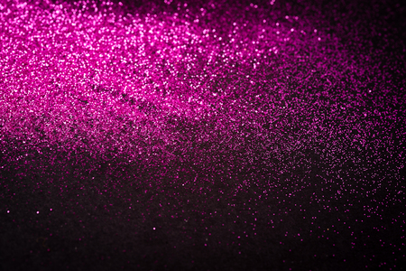 Pink glitter shaped on black background. Copy space.の写真素材