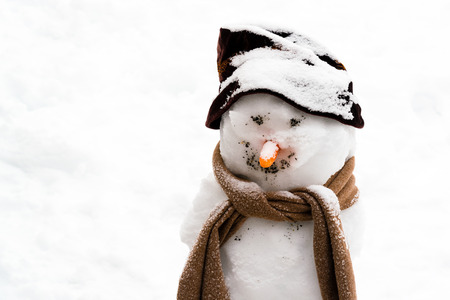 Smiling snowman with carrot nose, hat and scarf.の写真素材