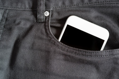 Close up of smartphone in front pocket on black pantsの写真素材