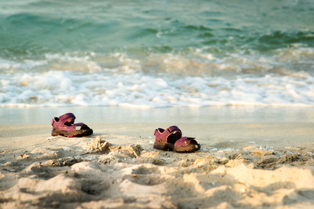 Pair of child sandals forgotten at the beachの写真素材