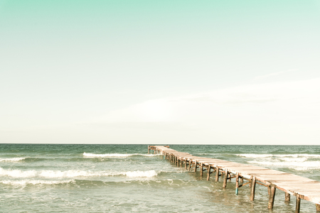 Retro look of a pier in the mediterranean ocean from the beachの写真素材