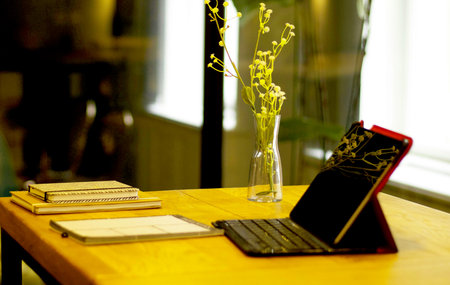 Laptop and notebook on the wooden table in coffee shop, stock photo
