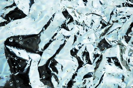 Crumpled metallic bag with water droplets backgroundの写真素材