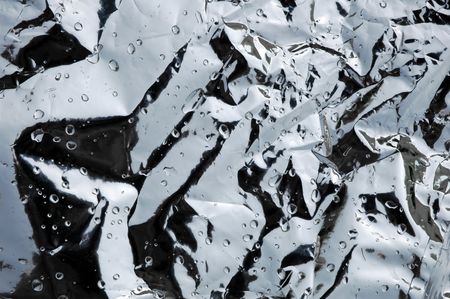 Crumpled metallic bag with water droplets backgroundの写真素材