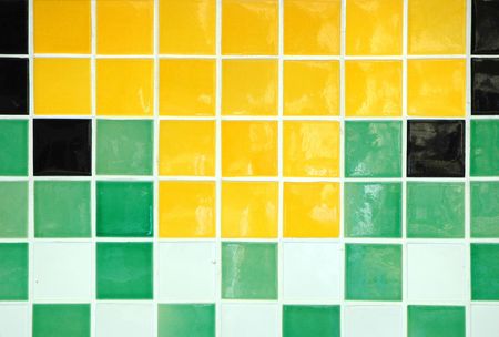 Old ceramic tile in green, yellow, white and blackの写真素材
