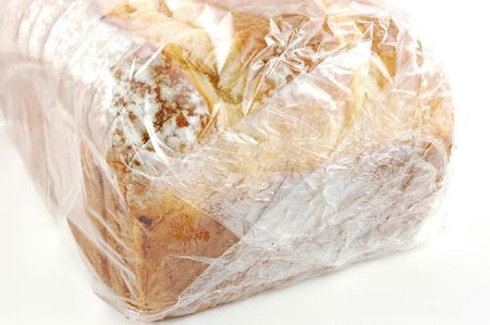 A loaf of bread wrapped in cellophane on an isolated white backgroundの写真素材