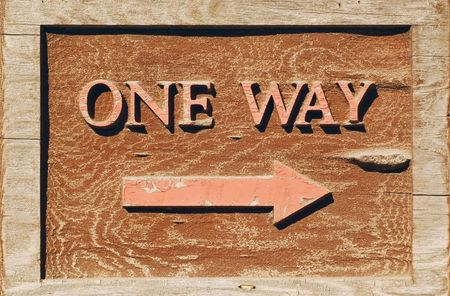 Hand carved one way sign with arrow pointing to the rightの写真素材