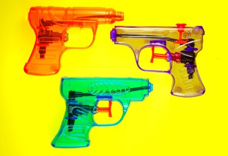 Toy squirt guns isolated on a yellow backgroundの写真素材