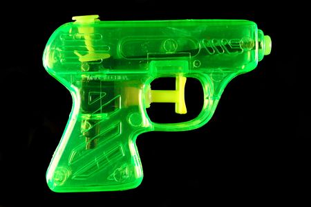 Toy squirt gun isolated on a black mirrored backgroundの写真素材