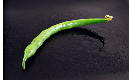 Fresh green bean on a watery black plateの写真素材