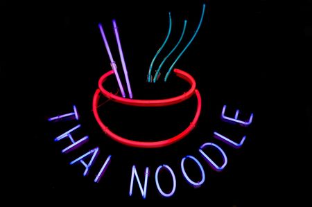 Neon sign advertising Thai noodle bowls at a restaurant
