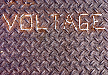 Voltage sign welded onto a manhole coverの写真素材