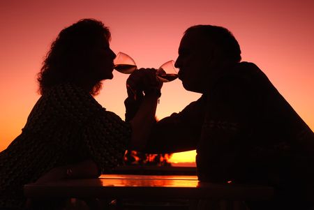 Romantic middle aged couple drinking wine at sunsetの写真素材